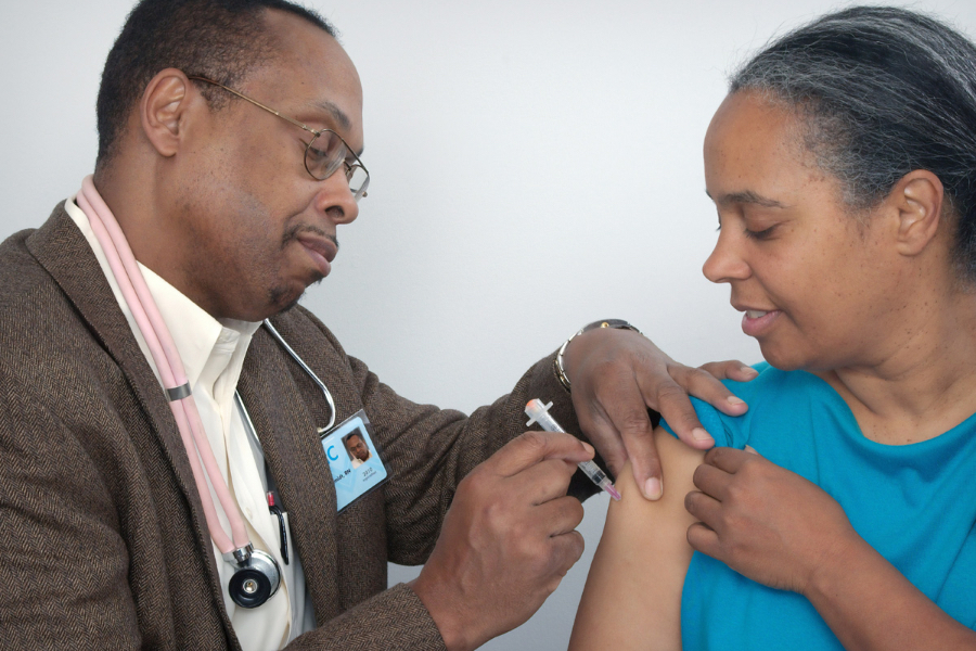 A patient receiving a shot in their upper arm.