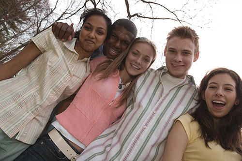 A group of teens huddled together and smiling