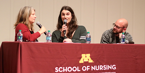 Panelists behind a table with the Block M and School of nursing on the tablecloth