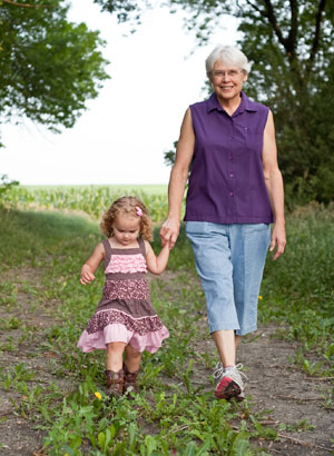 Elderly female walking hand in hand with a toddler