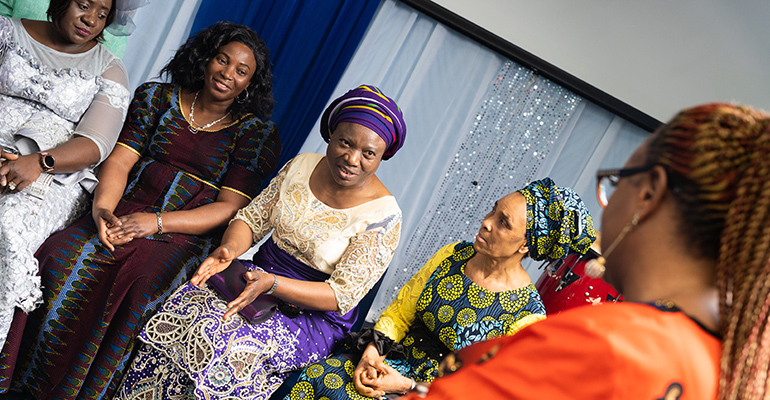 Blessing Azonwu celebrating her DNP in mental health with women wearing traditional Nigerian garb